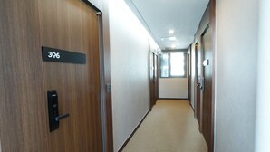 Un couloir avec des portes en bois, chacune portant un numéro.