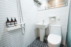 A bathroom with a toilet, sink, and shower. There are three bottles of shampoo, conditioner, and body wash on a shelf. - ZIYOLK Seoul Station (Seoul)