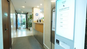 Un espace d’accueil d’hôtel doté d’un écran numérique affichant les options de sélection de la langue.
