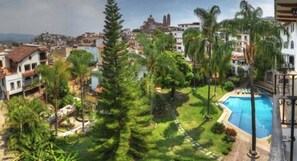 Residents enjoy a serene poolside setting surrounded by lush greenery and a variety of architectural styles.