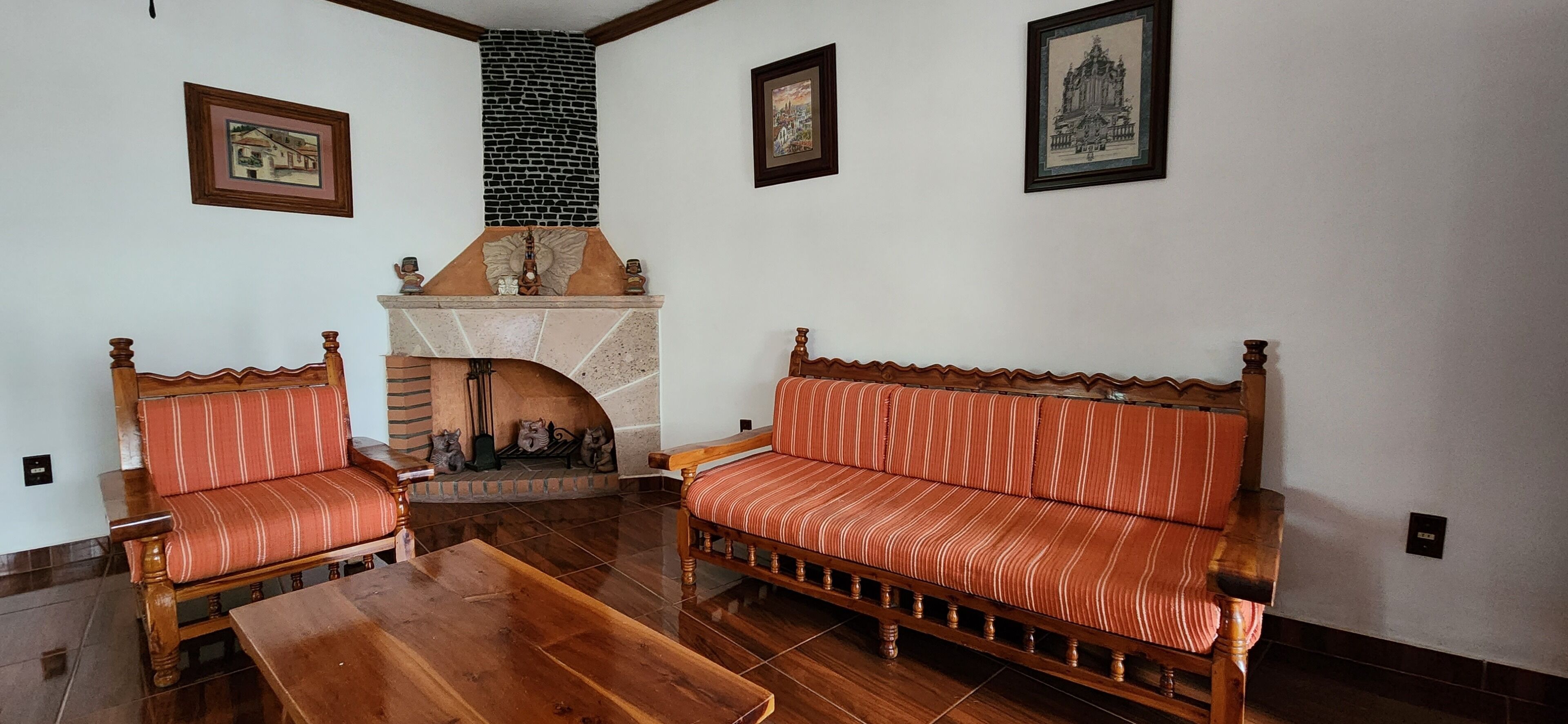 A living room with a fireplace, two sofas, and a wooden coffee table.