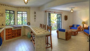 Amplia sala de estar con cocina, mesa de comedor y asientos.