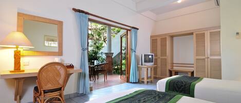 A hotel room with two beds, a desk with a chair, a television, and a view of the outdoors.