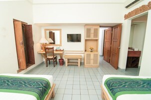 Une chambre avec deux lits, un bureau, une chaise, une télévision et une armoire.