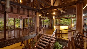 A multi-level wooden interior with a central staircase, large windows, and a reception area. - Mithi Resort & Spa (Dauis)
