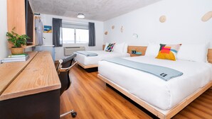 A modern hotel room with two beds, a wooden desk, a chair, a potted plant, and a window with curtains.