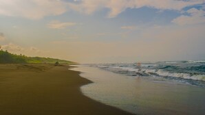 A beach with a sandy shore and waves. - Kenaki Lodge (Cahuita)