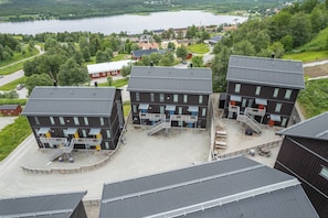 Un bâtiment moderne doté de nombreux balcons, d’une cour intérieure et offrant une vue sur un lac.