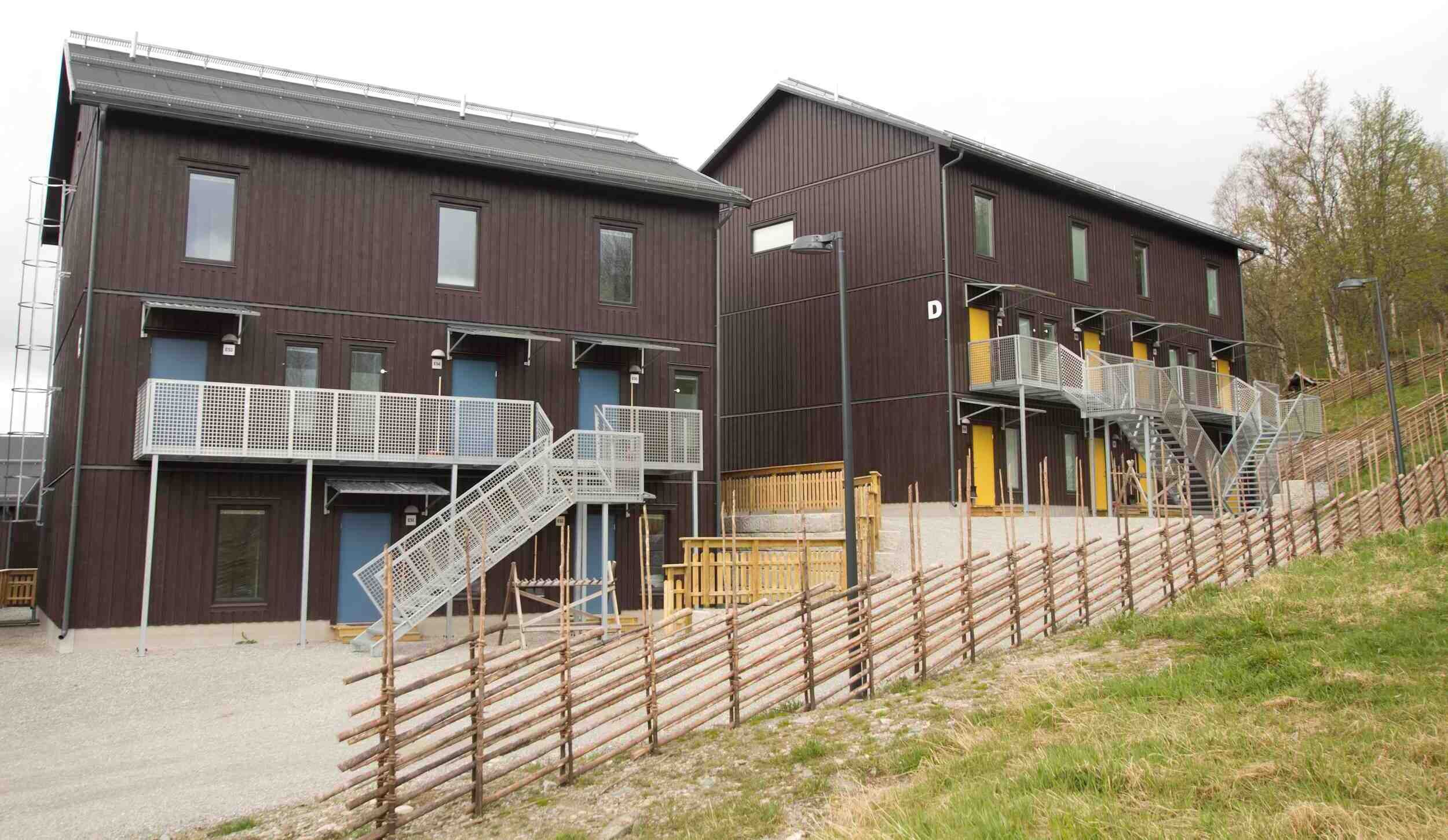 A modern building with two main structures, each featuring a balcony and a staircase.