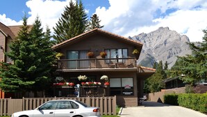 A lodge with a balcony, registration parking, and a mountain backdrop. - A Good Nite's Rest Bed and Breakfast (Banff)