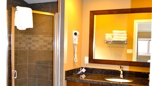 A bathroom with a glass-enclosed shower, a sink with a marble countertop, and a mirror with a towel rack above it. - A Good Nite's Rest Bed and Breakfast (Banff)