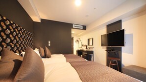 A modern hotel room with a large bed, a desk, a flat-screen TV, and a patterned wall. - Centurion Hotel Ikebukuro (Tokyo)