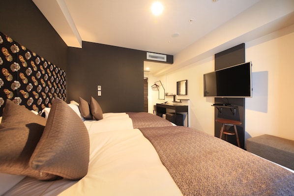 Una habitación de hotel moderna con una cama grande, un escritorio, un televisor de pantalla plana y una pared con diseño.