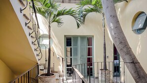 A multi-level interior with a staircase, potted plants, and a door with glass panels. - Casa Florida (San Miguel de Allende)
