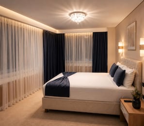 A modern hotel bedroom with a large bed, a chandelier, and sheer curtains. - Burçman Hotel (Bursa)