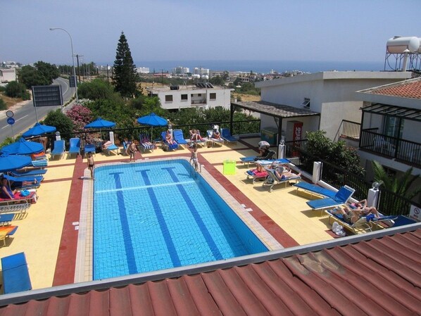 Una piscina al aire libre, sillones reclinables de piscina