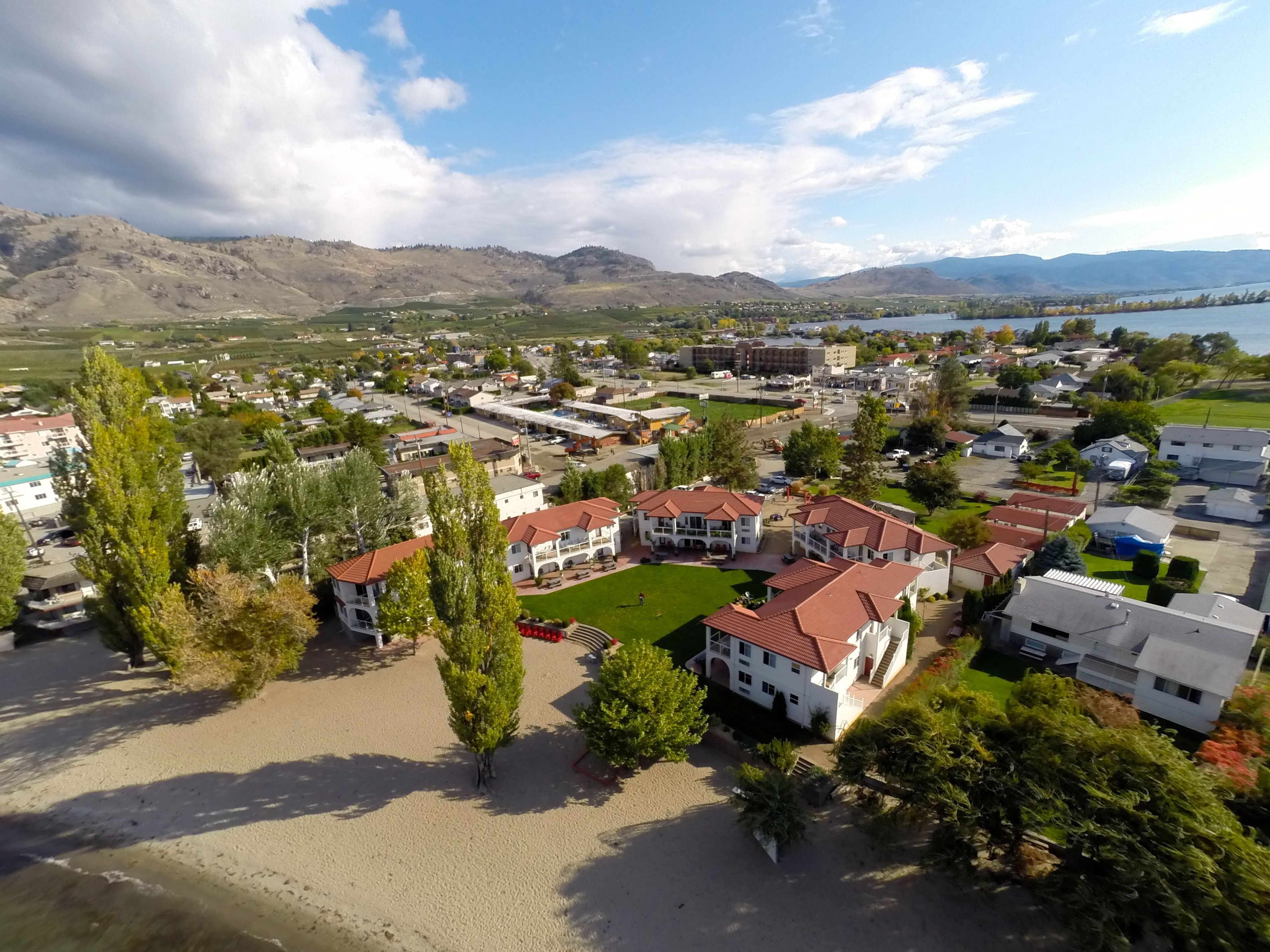 Un barrio residencial con casas, una playa y montañas al fondo.
