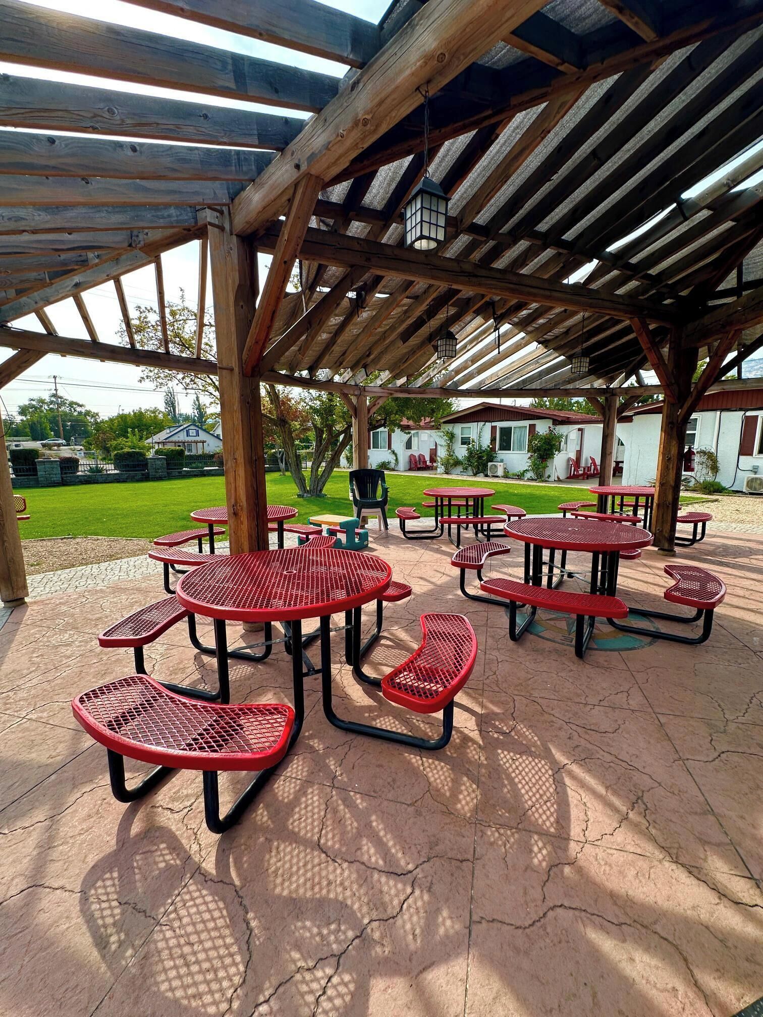 An outdoor covered picnic area with tables and benches.