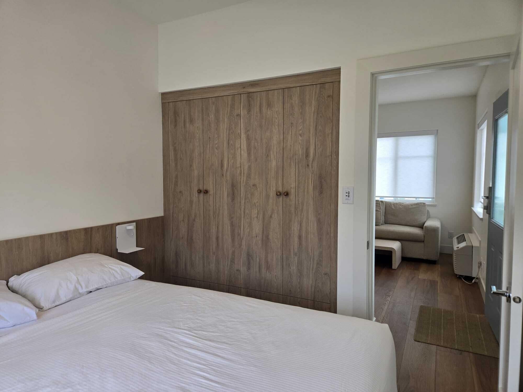 Une chambre à coucher avec un lit, une armoire, un canapé et une fenêtre.
