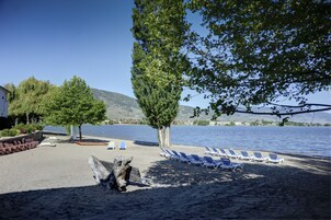 En la playa, sillas reclinables de playa, kayak, bote de remos