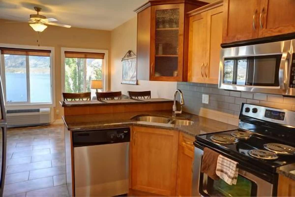 A kitchen with wooden cabinets, a dishwasher, a stove, and a microwave.