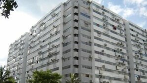 A multi-story residential building with balconies, air conditioning units, and a clear sky. - Deluxe at Popular Condo (Pak Kret)