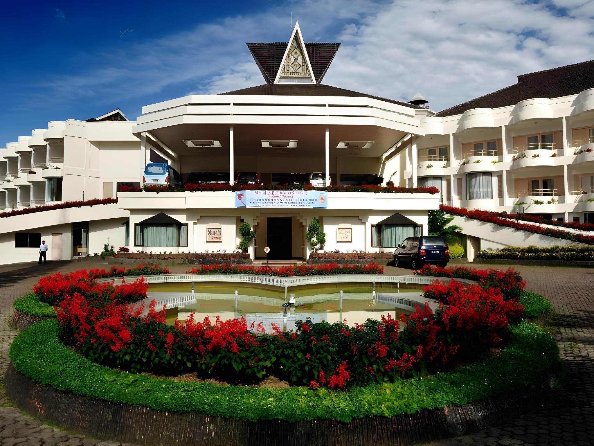 A hotel with a central courtyard, a fountain, and a multi-story building with balconies.