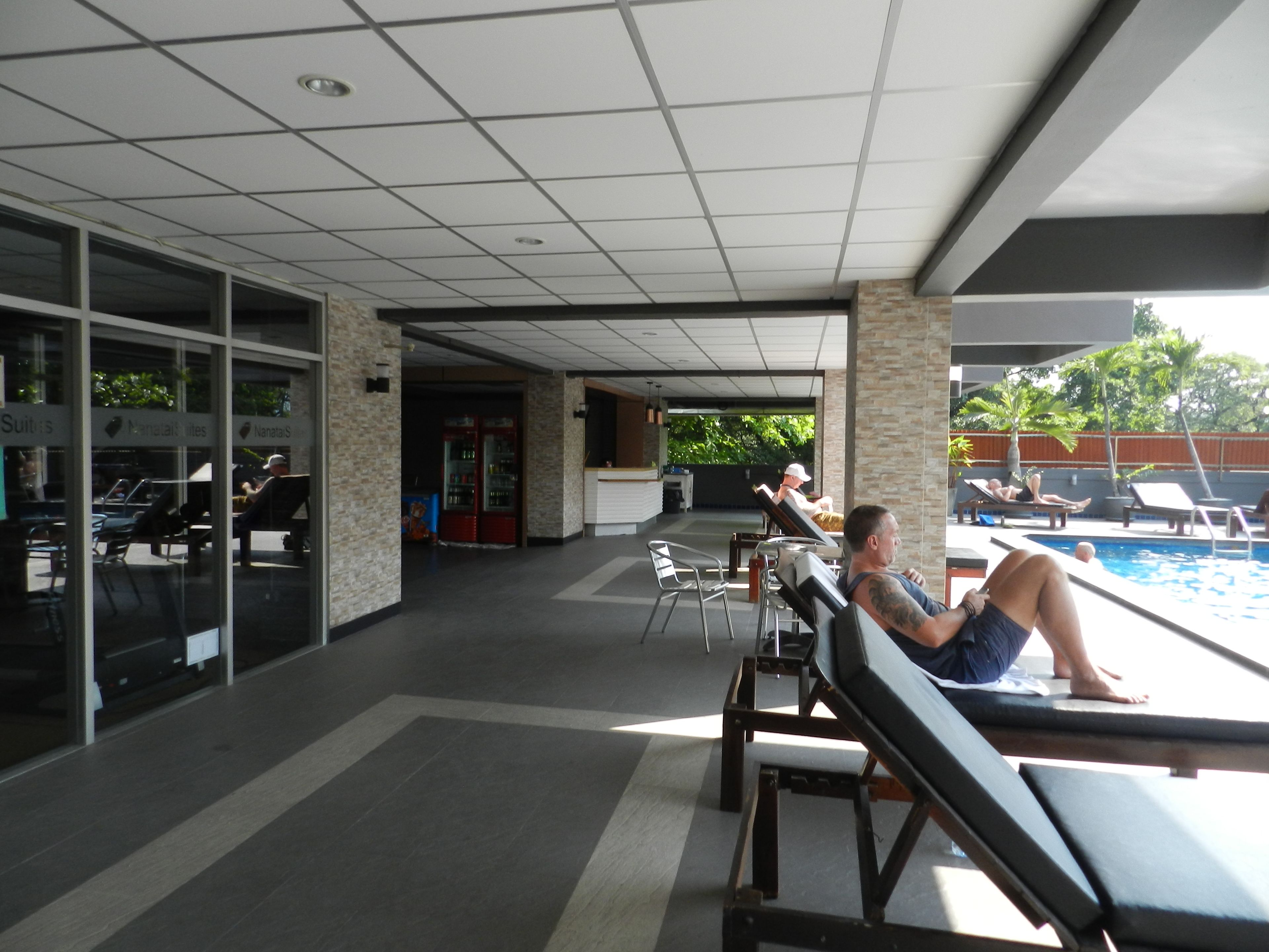 A poolside area with lounge chairs and a pool.