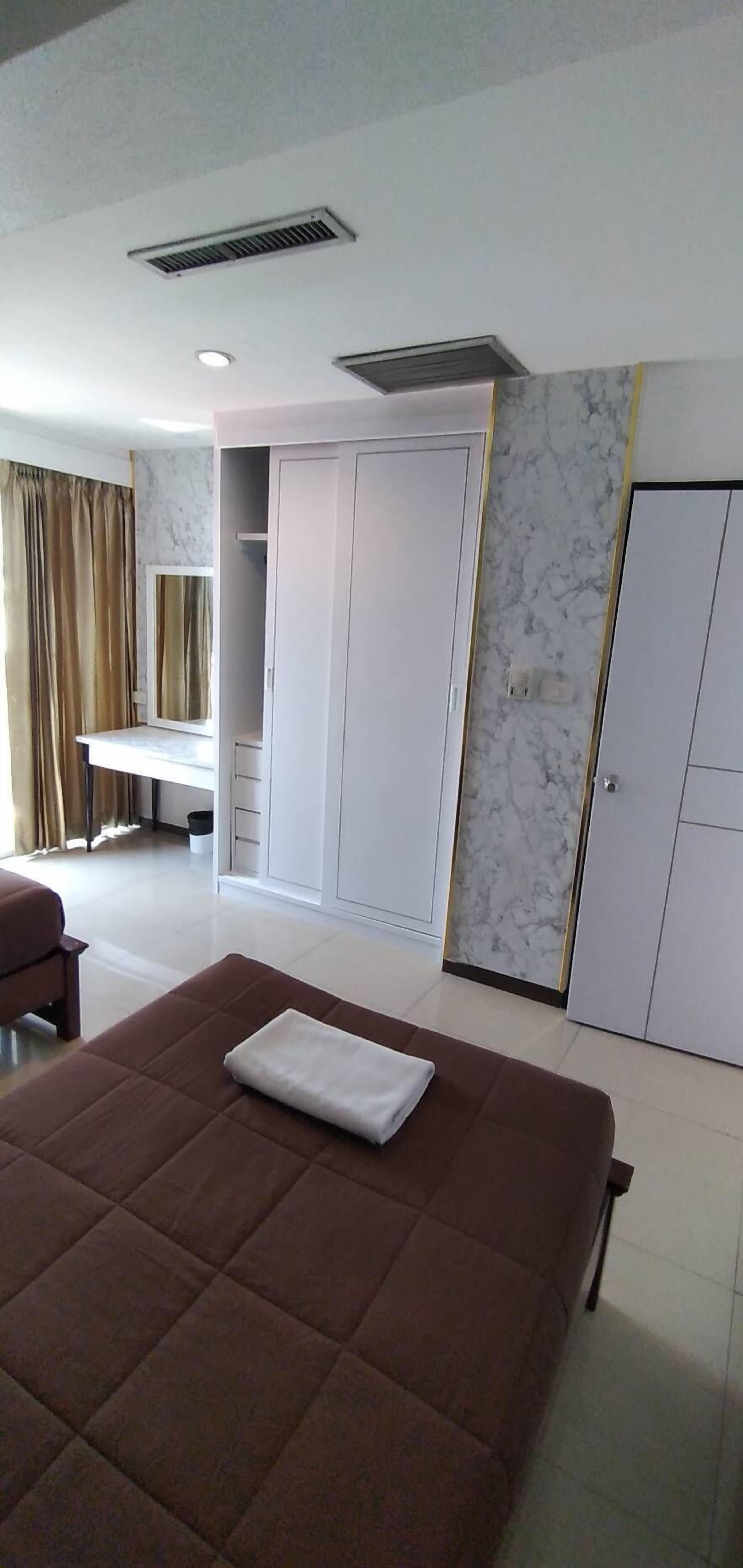 Une chambre à coucher avec un grand lit, une armoire, un bureau et un miroir.