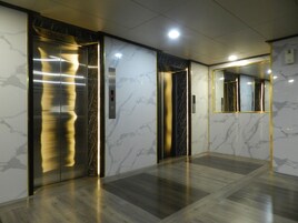 Egy digitális kijelzővel, márványfalakkal és csiszolt padlóval ellátott lift.