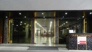 Entrada de un hotel con una recepción de mármol, un felpudo y un cartel que indica que no se permiten animales.