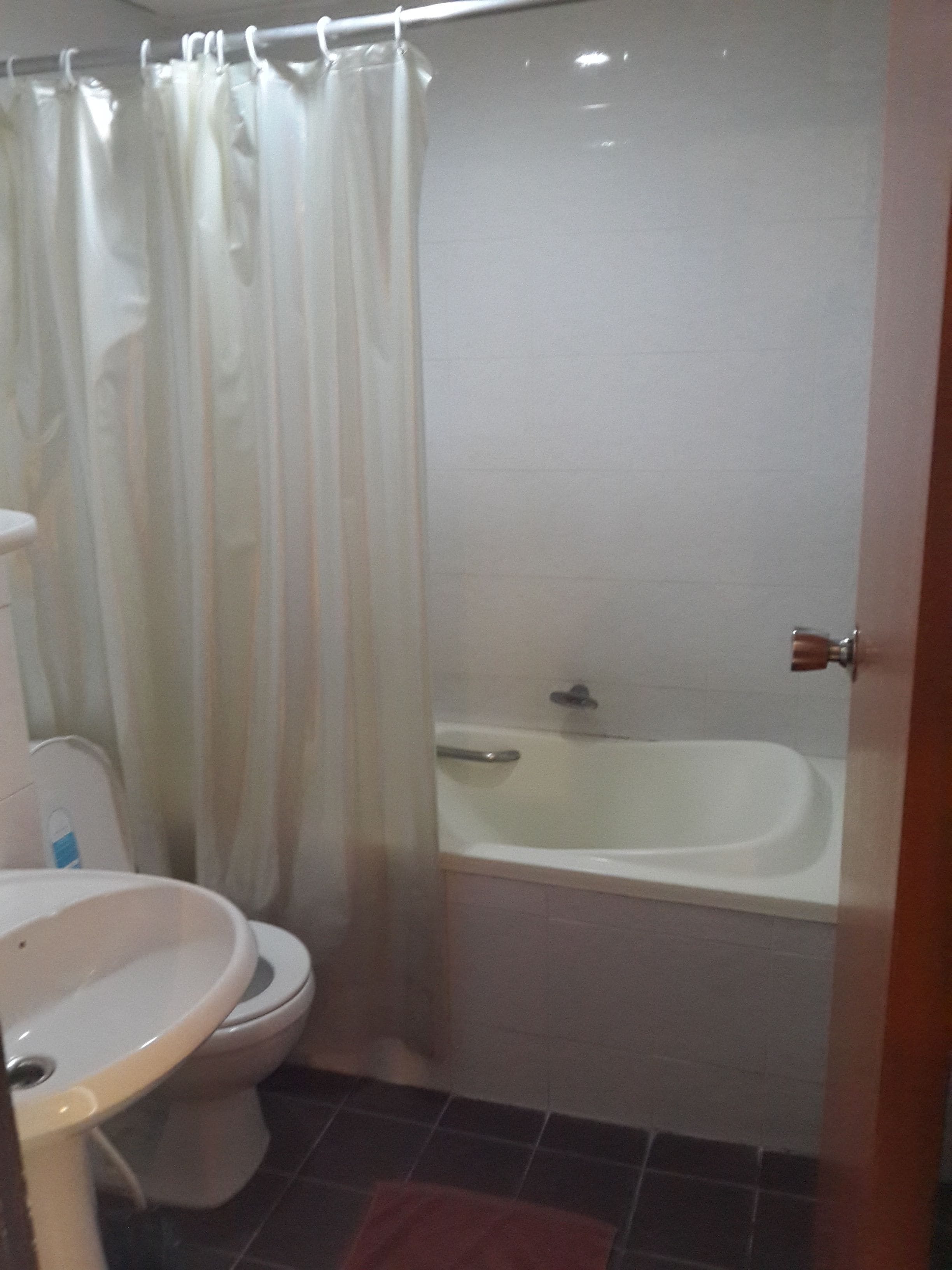 A bathroom with a toilet, sink, and bathtub.