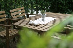 A wooden table with a potted plant and a white cloth.