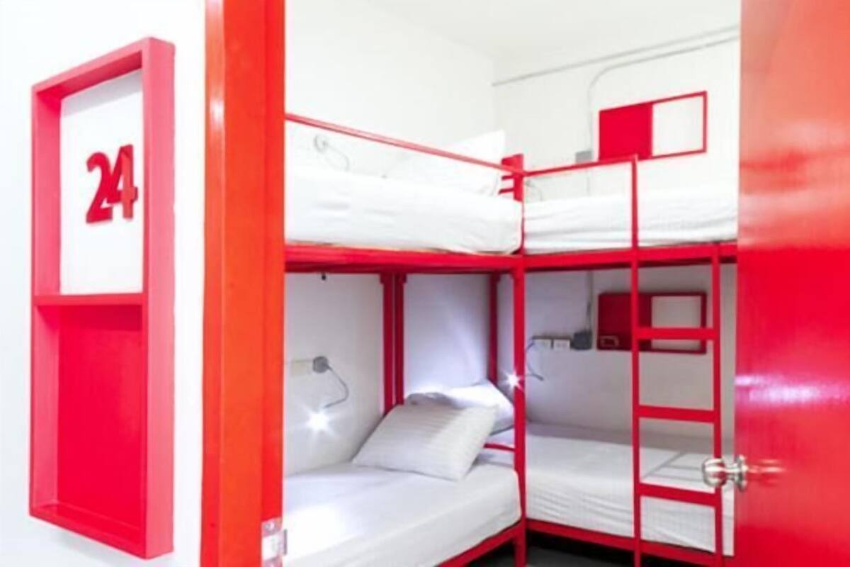 Een slaapkamer met een stapelbed, een rode deur en een bordje met het nummer 24.