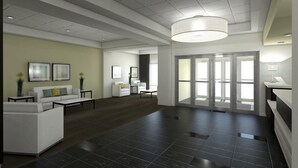 Un hall d’entrée spacieux au design moderne, comprenant un grand espace salon, un comptoir d’accueil et une grande fenêtre laissant entrer la lumière naturelle.