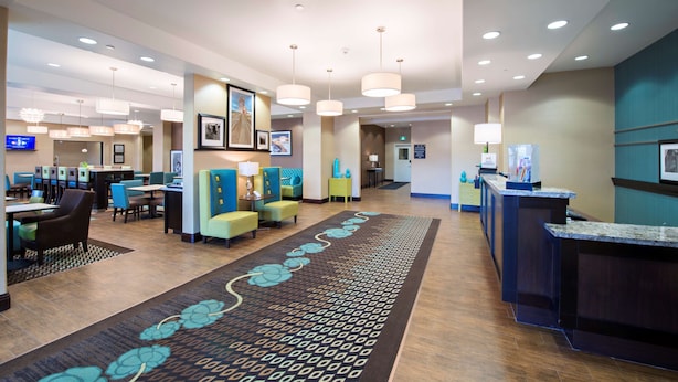 A hotel lobby with a reception desk, seating areas, and a patterned carpet. - Hampton Inn Saskatoon South (Saskatoon)