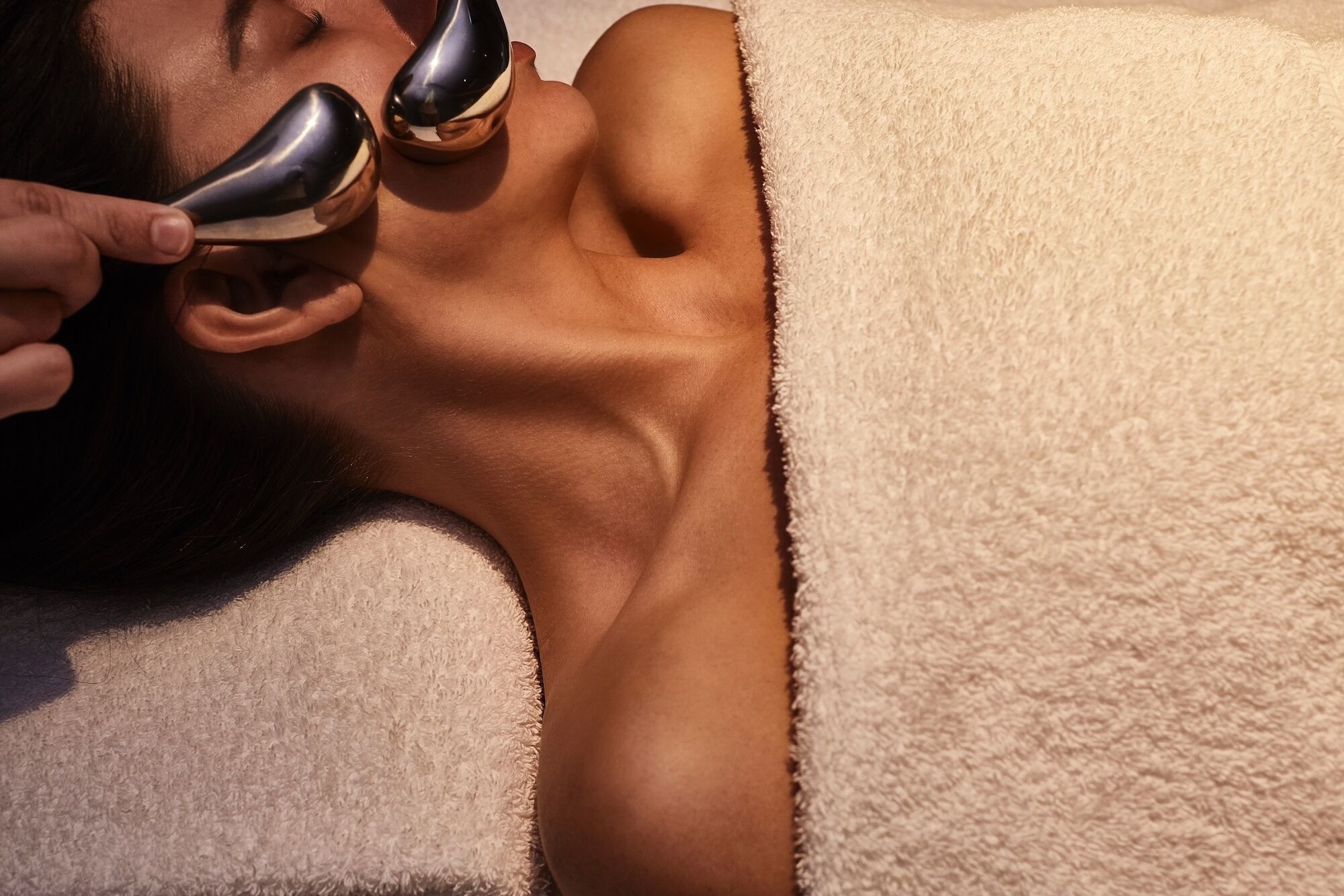 A person lying down with a towel covering their upper body.