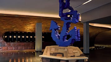 A modern interior with a unique sculpture centerpiece, a seating area, and a patterned wall.