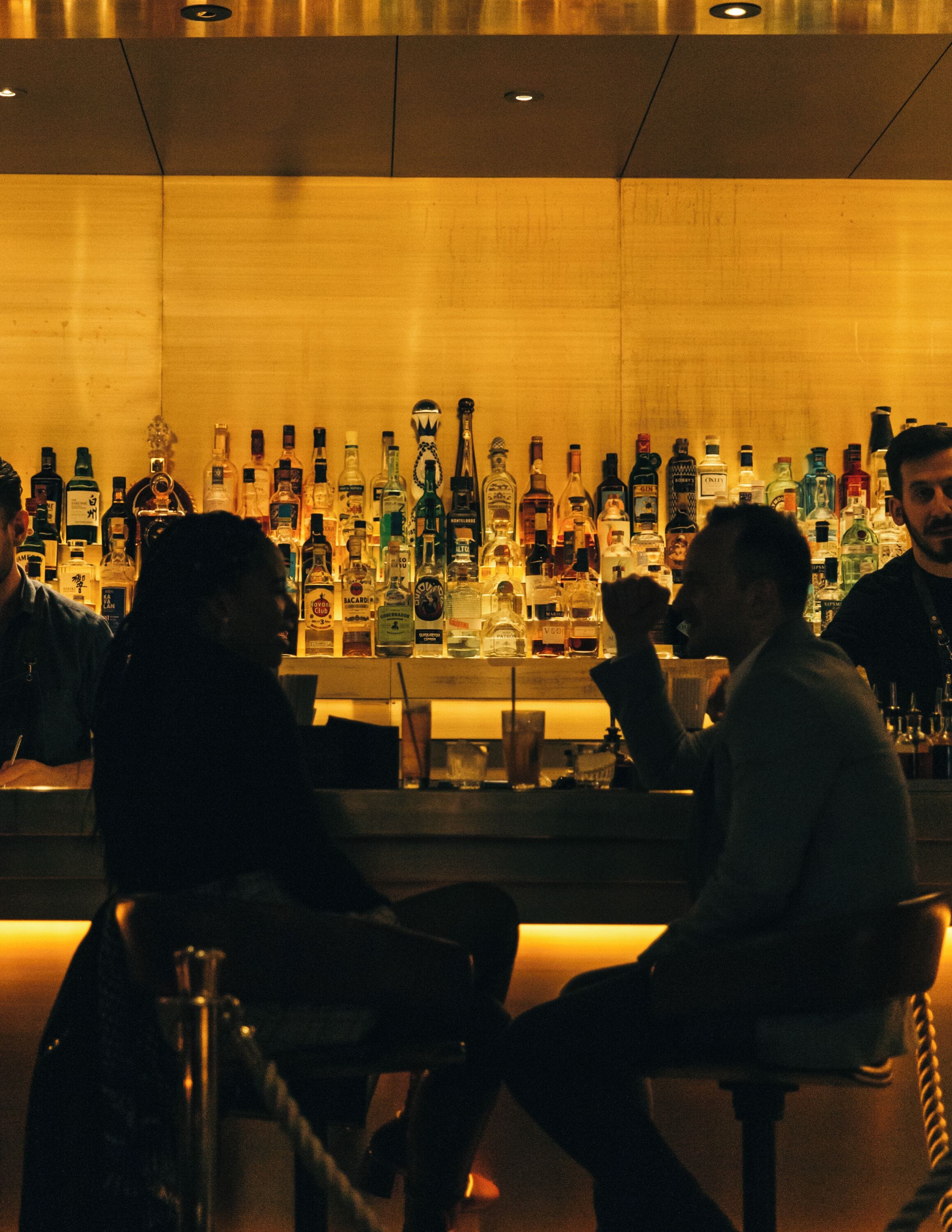 Zona de bar con varias botellas de licor y una barra.