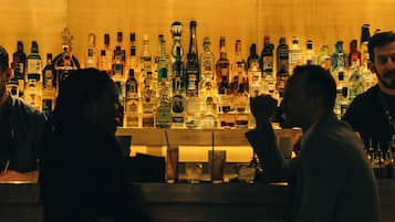 Zona de bar con varias botellas de licor y una barra.