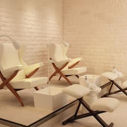 Relax in a serene space with two comfortable chairs, a small table, and a footrest.
