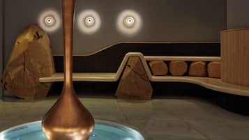 A spa area with a hot tub, wooden benches, and a unique copper structure.