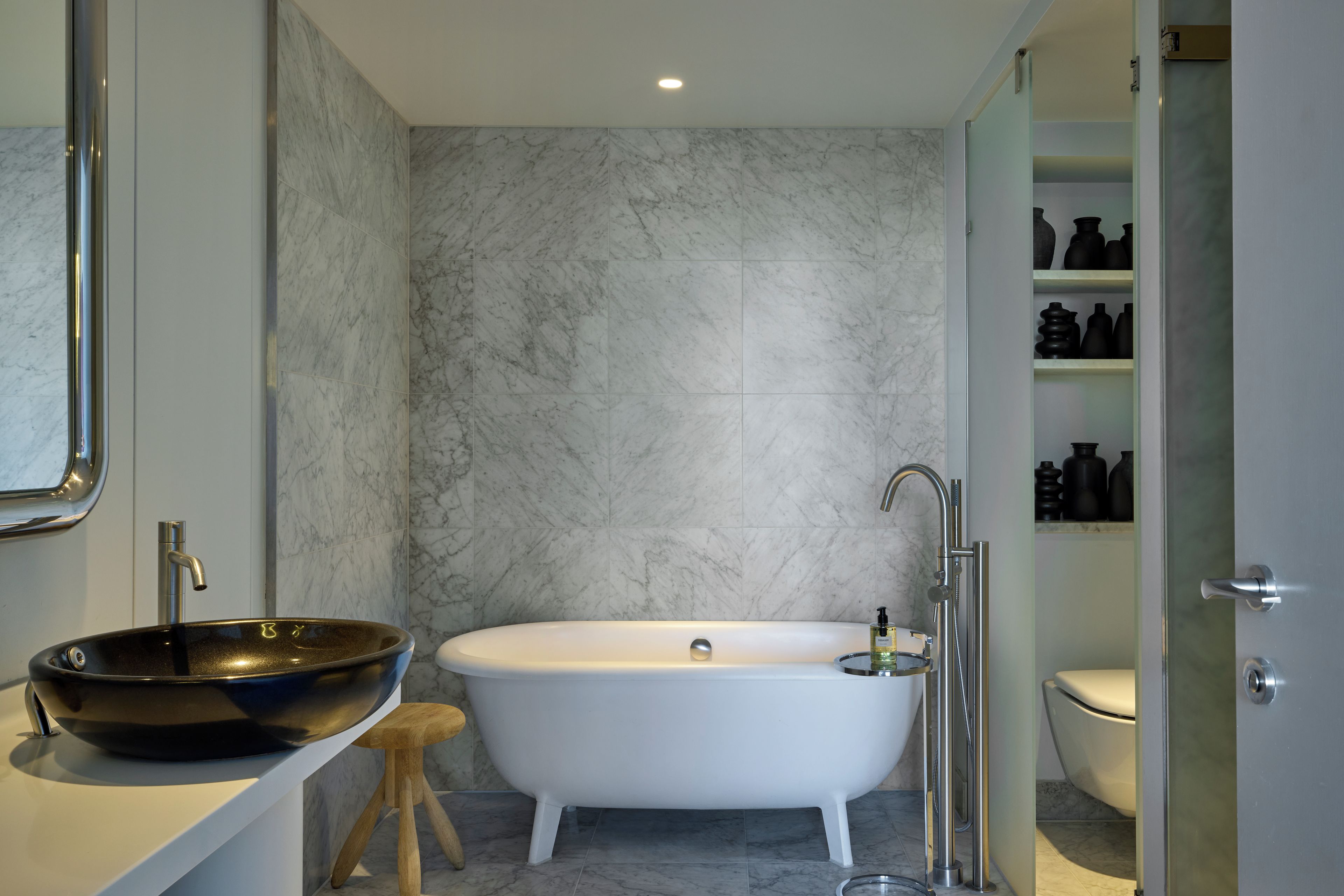 A bathroom with a freestanding bathtub, a vessel sink, and a toilet.