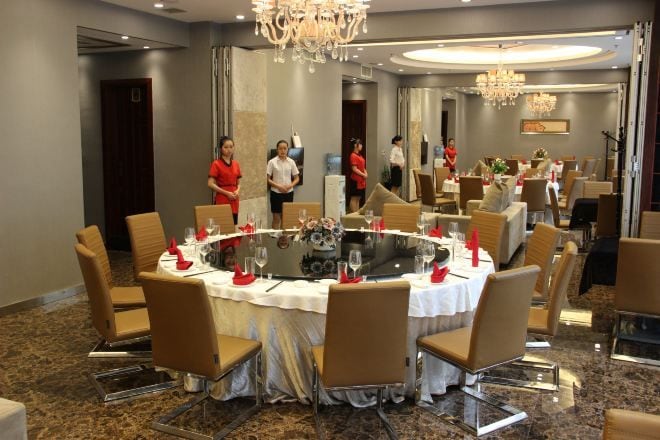 Une salle de conférence équipée d’une table ronde, de chaises et d’un lustre.