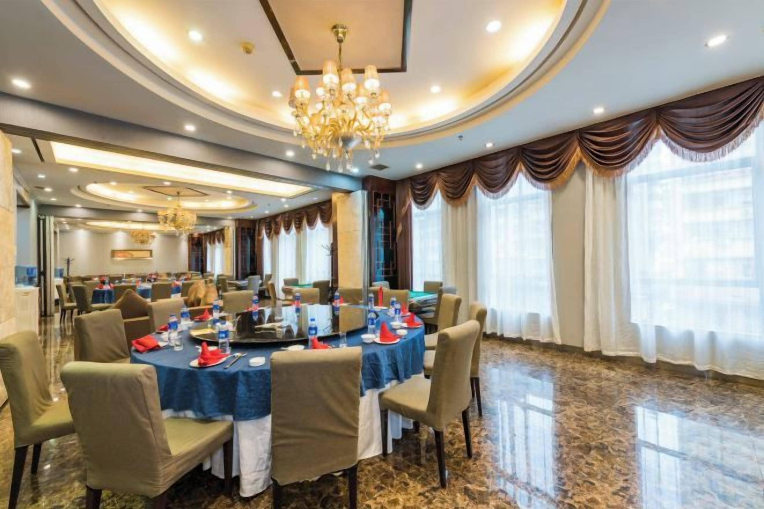 A conference room with round tables, chairs, and a chandelier.