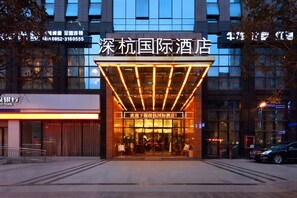 A hotel entrance with a modern design, featuring a prominent sign and a well-lit facade. - Shenhang International Hotel (Zunyi)