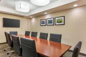 A conference room with a long table, six black chairs, a flat-screen TV, and three framed pictures on the wall. - Drury Plaza Hotel Phoenix Tempe (Tempe)