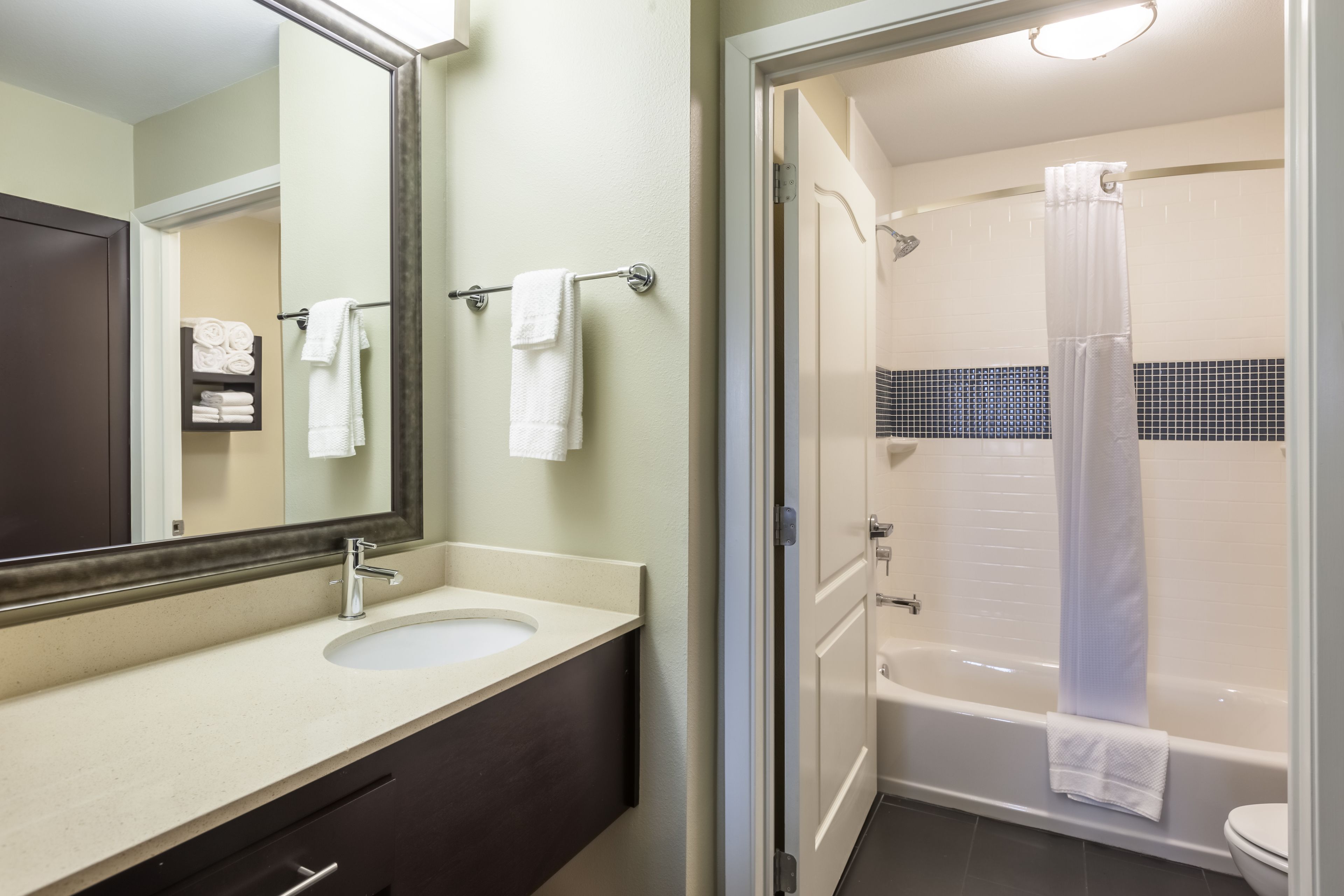 Une salle de bain avec un lavabo, un miroir et une douche.
