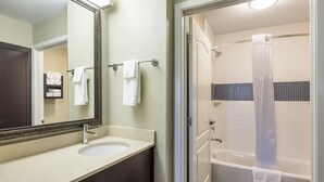 A bathroom with a sink, mirror, and shower. - Staybridge Suites Houston I-10 West-beltway 8 by IHG (Houston)