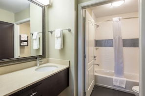 Un baño con lavamanos, espejo y ducha.